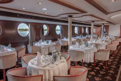 a dining car on a train with tables and chairs at Jaz Celebrity Nile Cruise - Every Saturday from Luxor for 07 & 04 Nights - Every Wednesday From Aswan for 03 Nights in Luxor