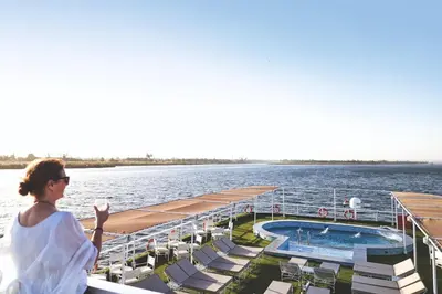a woman standing on the deck of a cruise ship at JAZ Imperial Nile Imperial Cruise - Every Thursday from Luxor- Aswan- Luxor for 07 Nights in Luxor