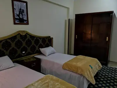 a hotel room with two beds and a cabinet at Luxor hotel Bella Vista Apartments and Hotel in Luxor