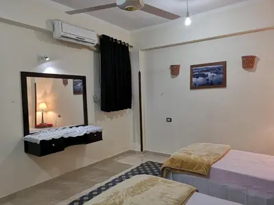 a room with two beds and a mirror at Luxor hotel Bella Vista Apartments and Hotel in Luxor