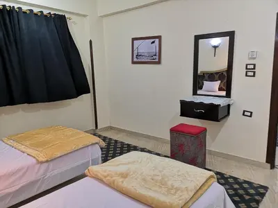 a room with two beds and a mirror on the wall at Luxor hotel Bella Vista Apartments and Hotel in Luxor