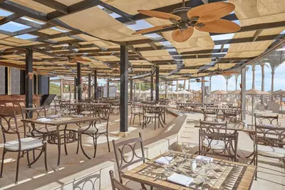 a restaurant with tables and chairs and a ceiling fan at Steigenberger Aqua Magic, All inclusive in Hurghada
