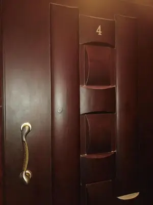 a wooden door with a handle and a book shelf at Studio Apartment at Tiba Star in Hurghada