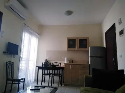 a kitchen with a refrigerator and a table with chairs at Studio Apartment at Tiba Star in Hurghada