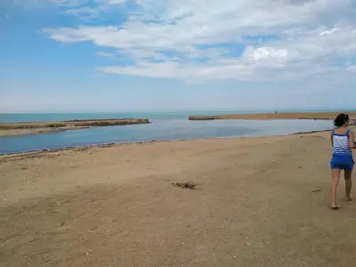 a woman standing on a beach looking at the water at Studio Apartment at Tiba Star in Hurghada