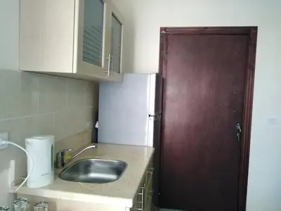 a kitchen with a sink and a wooden door at Studio Apartment at Tiba Star in Hurghada