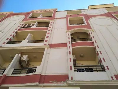 a red and white building with open balconies at Studio Apartment at Tiba Star in Hurghada