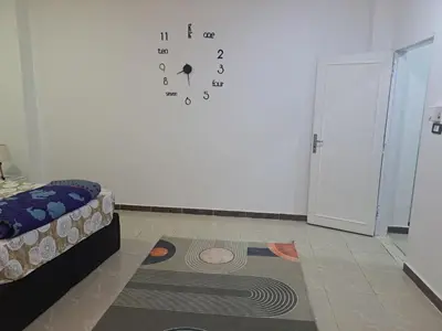 a room with a clock on a white wall at Sweet Home- ممنوع للمصريين Open 24 Hour in Hurghada
