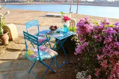 a table with two chairs and a vase of flowers at Beit Matta in Hurghada