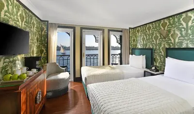 a hotel room with two beds and a balcony at Movenpick SS Misr Steamer Nile Cruise - 04 & 07 Nights Each Monday From Luxor and 03 Nights Each Friday from Aswan in Luxor
