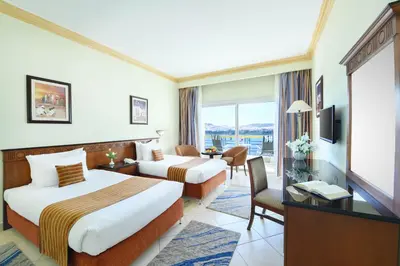 a hotel room with two beds and a television at Tolip Aswan Hotel in Aswan