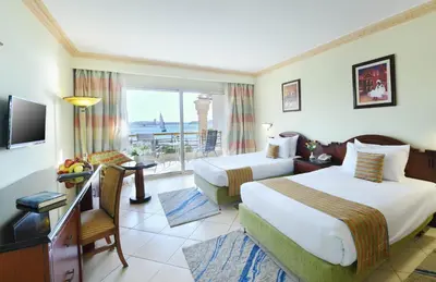 a hotel room with two beds and a television at Tolip Aswan Hotel in Aswan