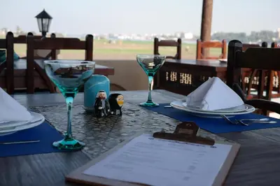 a table with two wine glasses and a menu on it at Djorff Palace in Luxor