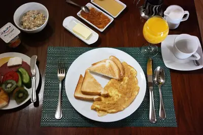 a table with a plate of food with toast and eggs at Djorff Palace in Luxor