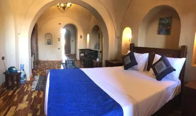 a bedroom with a large bed with a blue blanket at Djorff Palace in Luxor