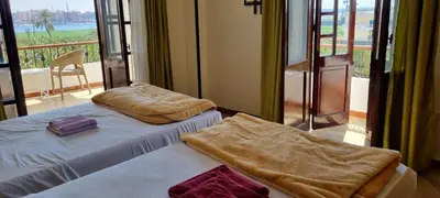 a hotel room with two beds with a balcony at DREAM ISLAND Hotel in Luxor