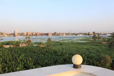 a table with a view of the river and a city at DREAM ISLAND Hotel in Luxor