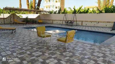 a patio with a table and chairs next to a pool at DREAM ISLAND Hotel in Luxor