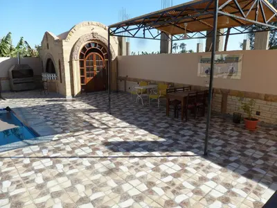 a patio with a table and chairs in front of a building at DREAM ISLAND Hotel in Luxor