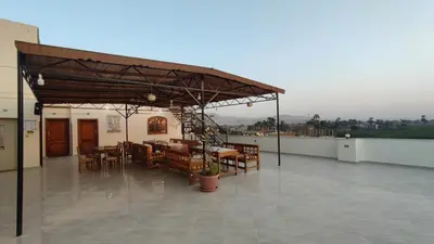 a patio with tables and chairs on a roof at DREAM ISLAND Hotel in Luxor
