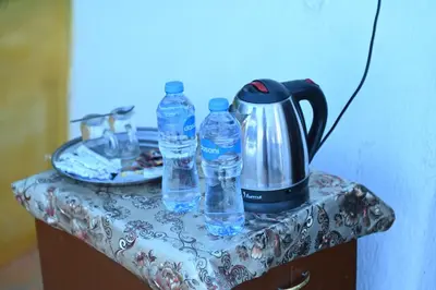 a table with two bottles of water and a tea kettle at Opal privat nubian hotel in Aswan