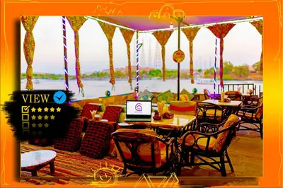 a restaurant with tables and chairs with a laptop on it at Opal privat nubian hotel in Aswan