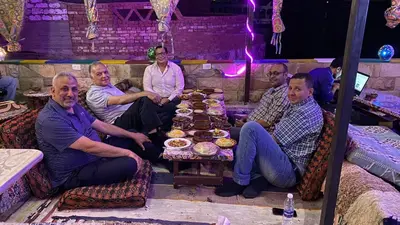 a group of people sitting around a table with food at Opal privat nubian hotel in Aswan