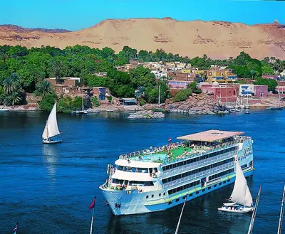a cruise ship in the water with sail boats at SUNRISE Mahrousa Cruise in Luxor