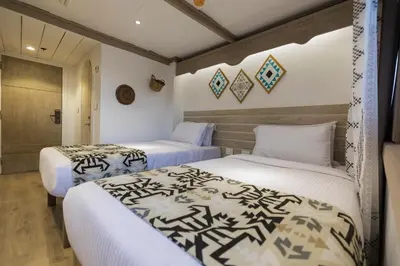 two beds in a room with white walls at SUNRISE Mahrousa Cruise in Luxor