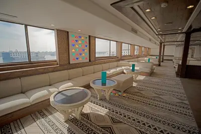 a waiting room with a couch and tables and windows at SUNRISE Mahrousa Cruise in Luxor