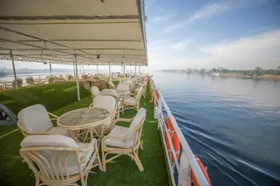 a group of tables and chairs on a boat on the water at SUNRISE Mahrousa Cruise in Luxor
