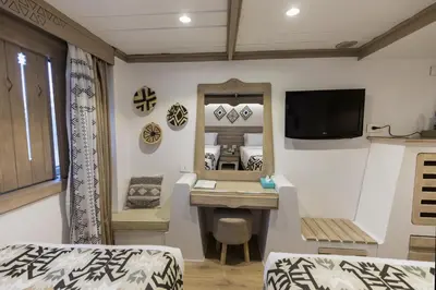 a room with a bedroom with a desk and a mirror at SUNRISE Mahrousa Cruise in Luxor