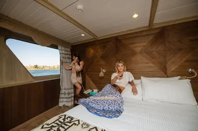 two women sitting in a bed in a boat at SUNRISE Mahrousa Cruise in Luxor
