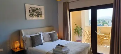a bedroom with a bed with a view of a balcony at Luxury Hurghada Self-Catering Apartments & Studios, Al Dau Heights in Hurghada