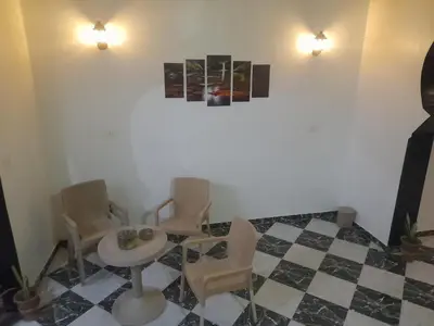 a room with a table and chairs and a checkered floor at Alaa Aldin Flats in Luxor