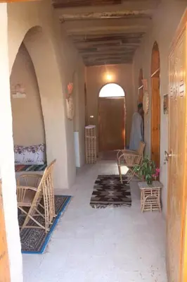 a hallway of a house with chairs and a door at Desert Rose Guesthouse in Luxor