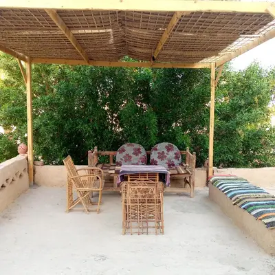 a patio with a table and chairs under a pavilion at Desert Rose Guesthouse in Luxor