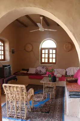 a living room with a table and chairs in a room at Desert Rose Guesthouse in Luxor