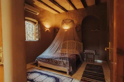 a bedroom with a bed with a mosquito net at Desert Rose Guesthouse in Luxor