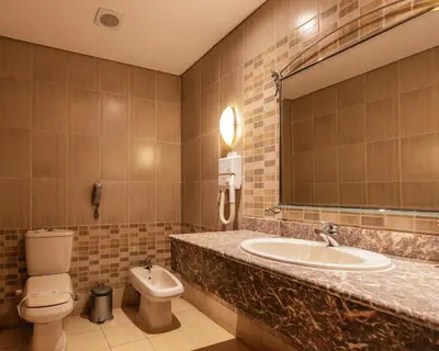 a bathroom with a sink and a toilet and a mirror at AMC Royal Hotel & Spa in Hurghada