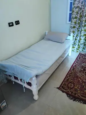 a small bed in a room with a rug at Roma House in Aswan