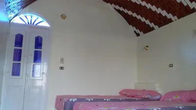 a room with a bed and a door and a ceiling at Roma House in Aswan