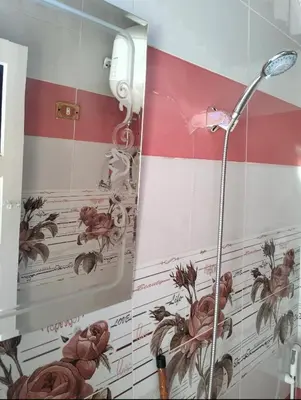 a shower in a bathroom with flowers on the wall at Roma House in Aswan