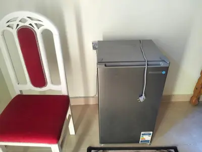 a small refrigerator and a red chair in a room at Roma House in Aswan