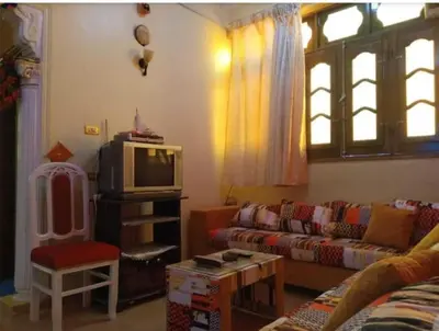 a living room with a couch and a tv at Roma Guest house in Aswan