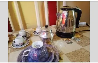 a coffee pot and cups on a counter at Roma Guest house in Aswan