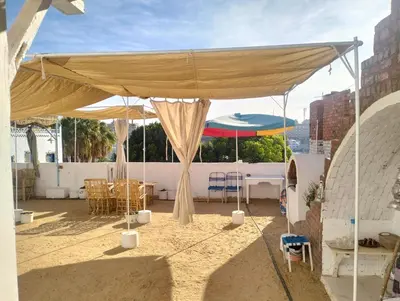 a tent with a table and chairs under it at Roma Guest house in Aswan