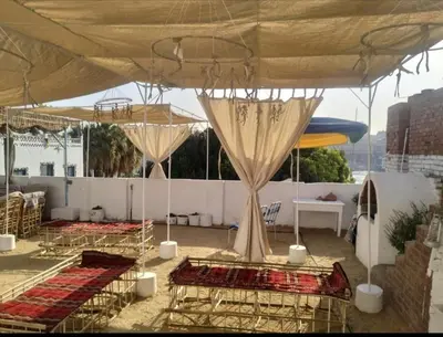 two beds under a tent on a roof at Roma Guest house in Aswan