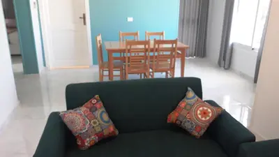 a living room with a couch and a table with chairs at New Modern Flats in Luxor