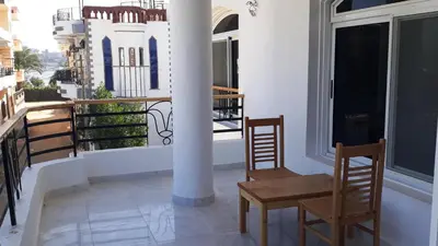 a balcony with two chairs and a pole at New Modern Flats in Luxor